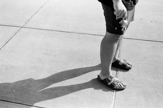 grayscale photo of person in black shorts and black nike shoes
