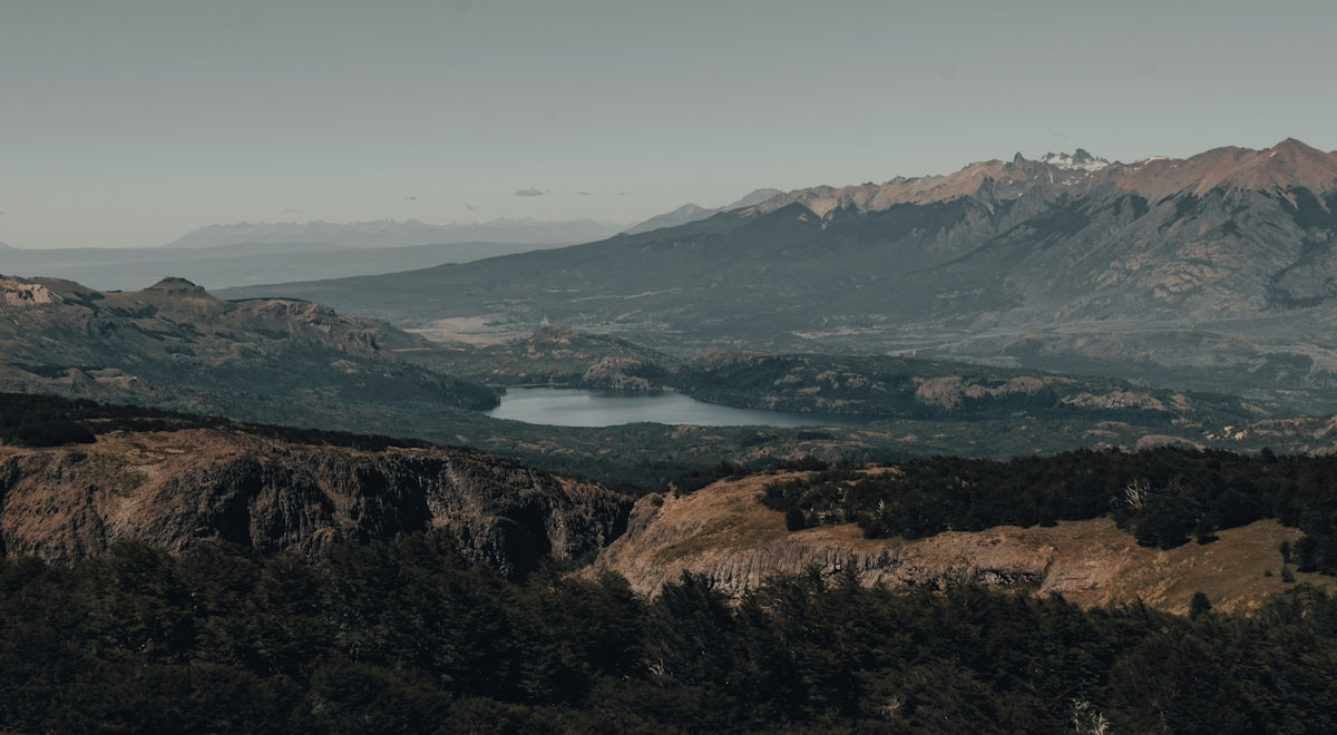 green and brown mountains near body of water during daytime