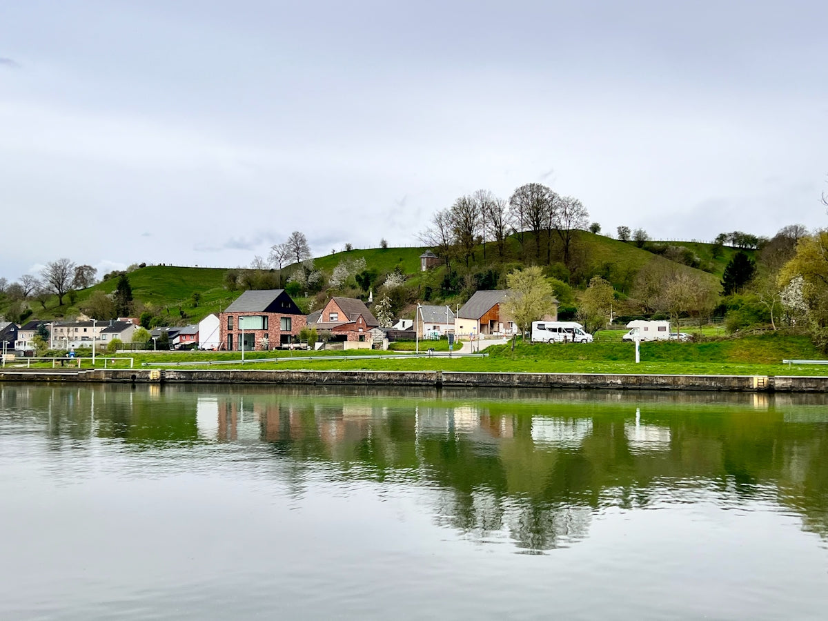a body of water with houses on a hill in the background