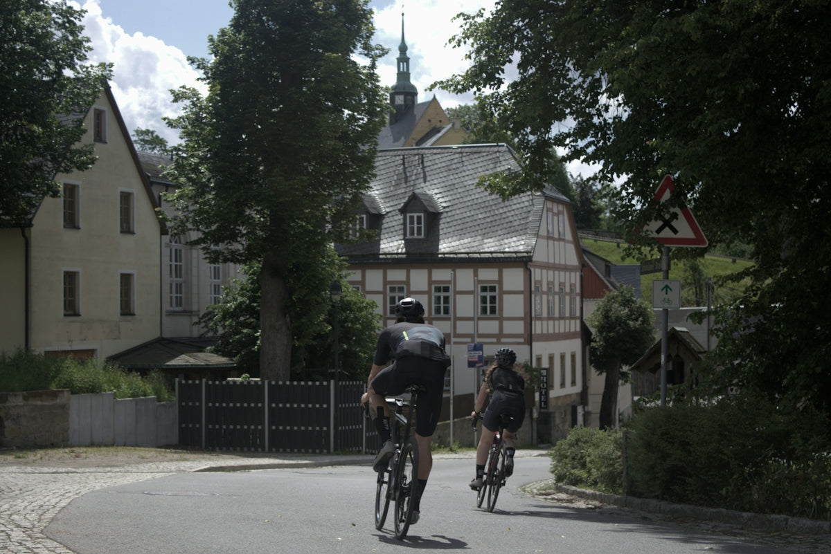 A couple of people riding bikes down a street