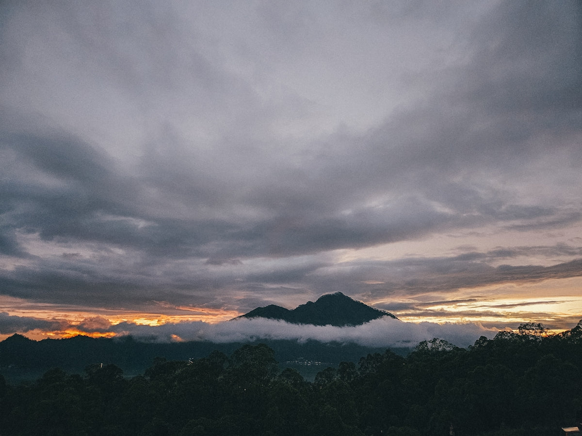 A view of a mountain with clouds in the sky