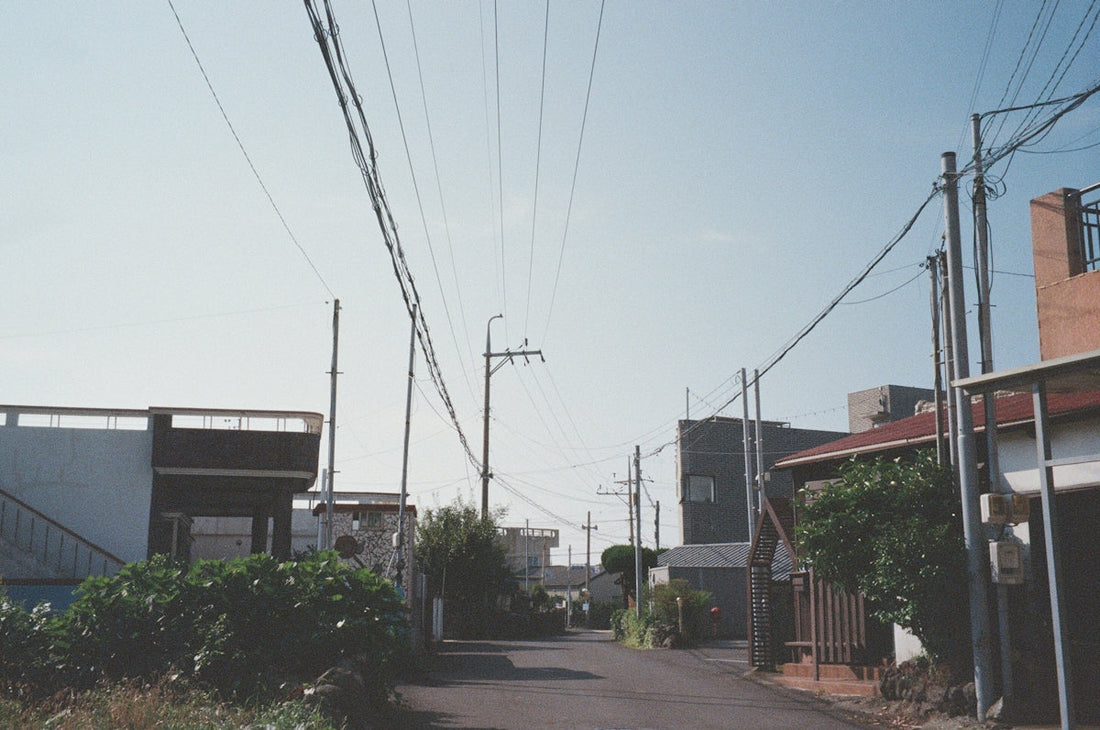A quiet street with power lines and buildings.