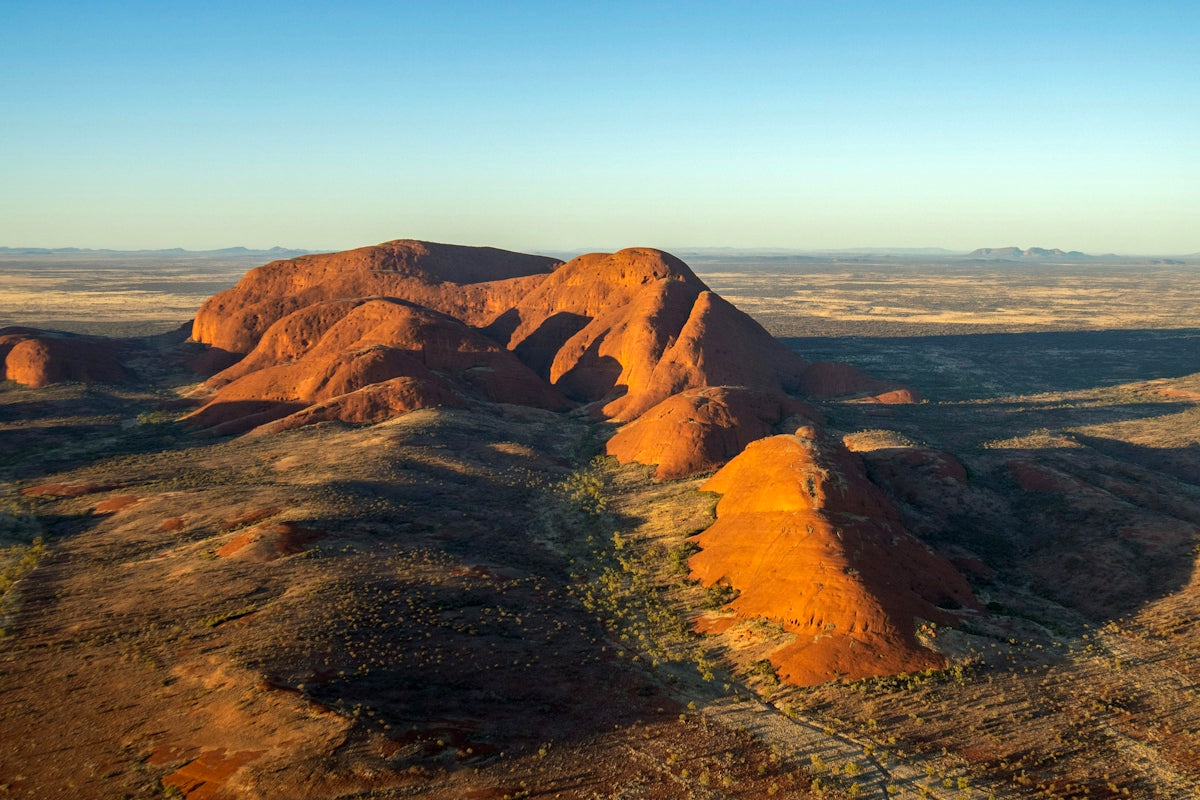 Red desert landscape with large rock formations at sunrise