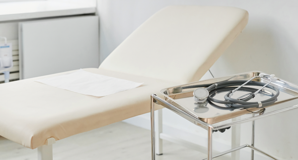 Illustrative photograph of an examination couch and clinical instrument tray