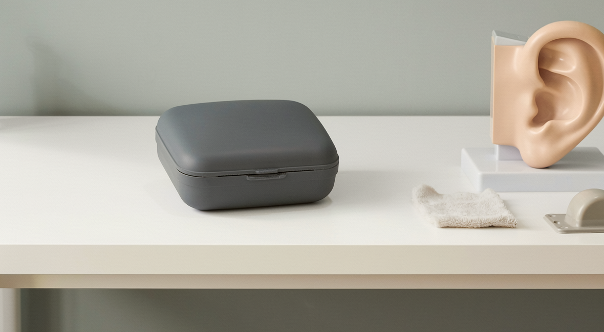 Illustrative photograph of a hearing-aid case and ear model