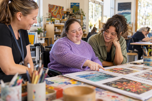 NDIS participant enjoying an inclusive arts activity with a friend and support worker