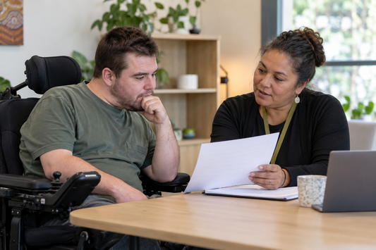 NDIS participant reviewing a decision letter with an independent disability advocate