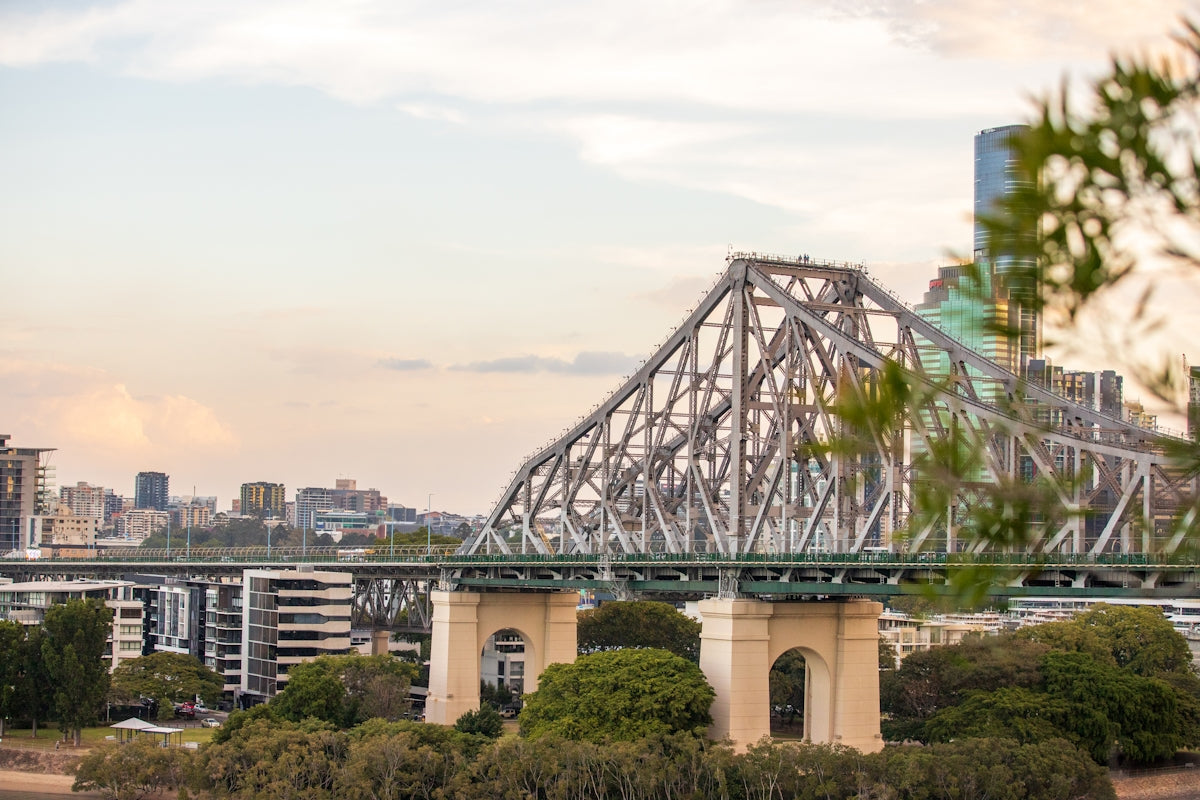a bridge over a river with a city in the background