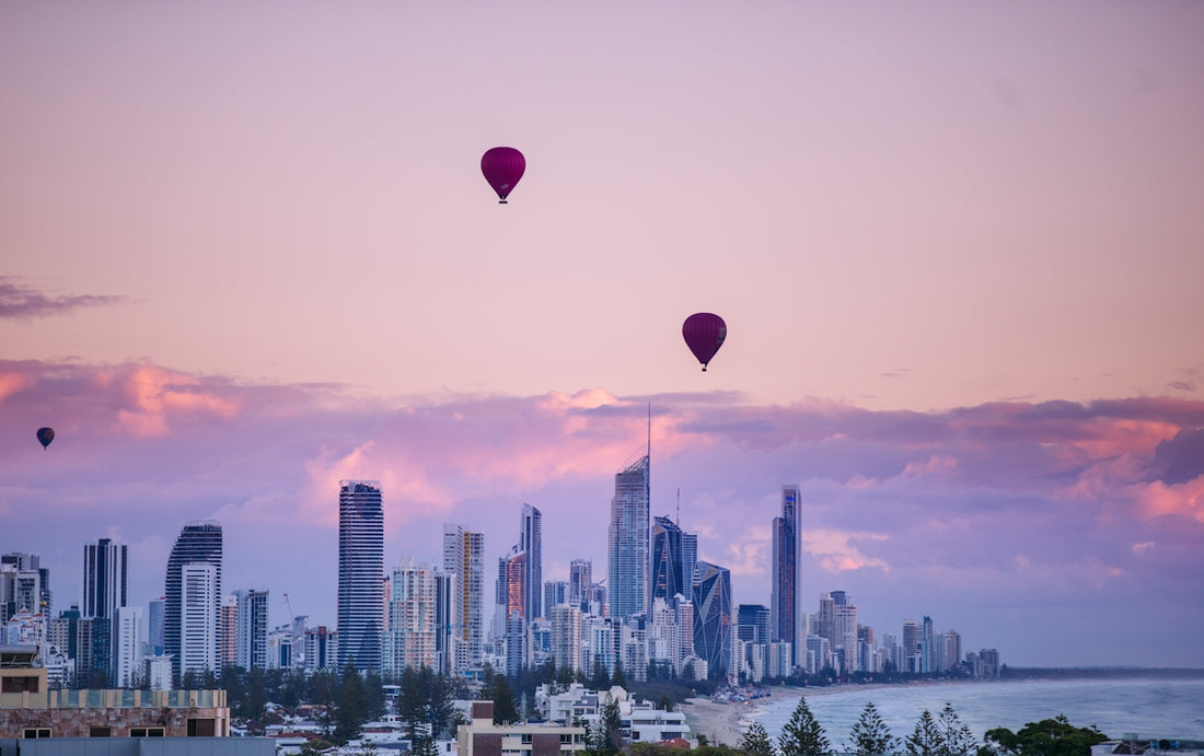 red and blue hot air balloons over city skyline during sunset