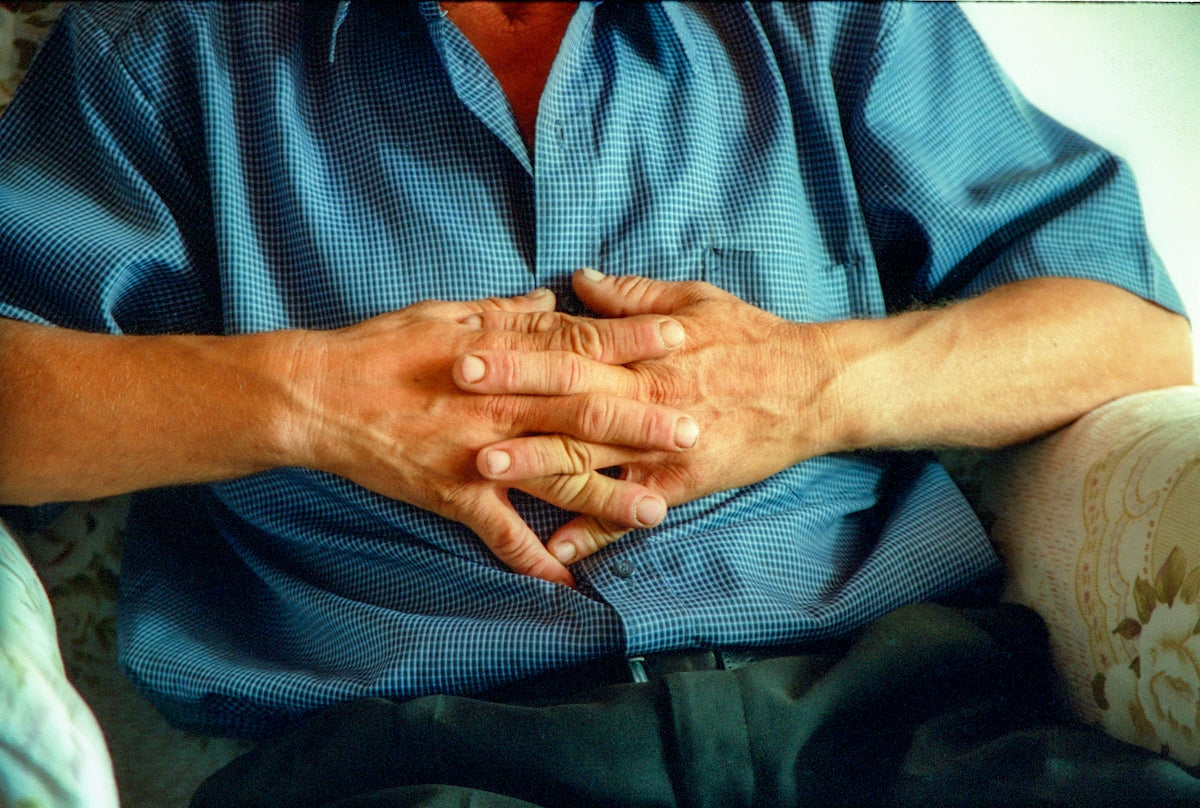 a man sitting on a couch holding his hands together