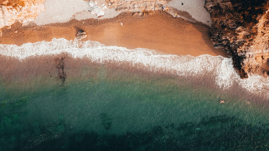 a body of water with a rocky cliff in the background