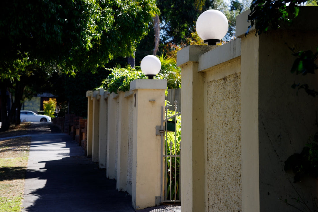 a street with a fence and two lamps on it
