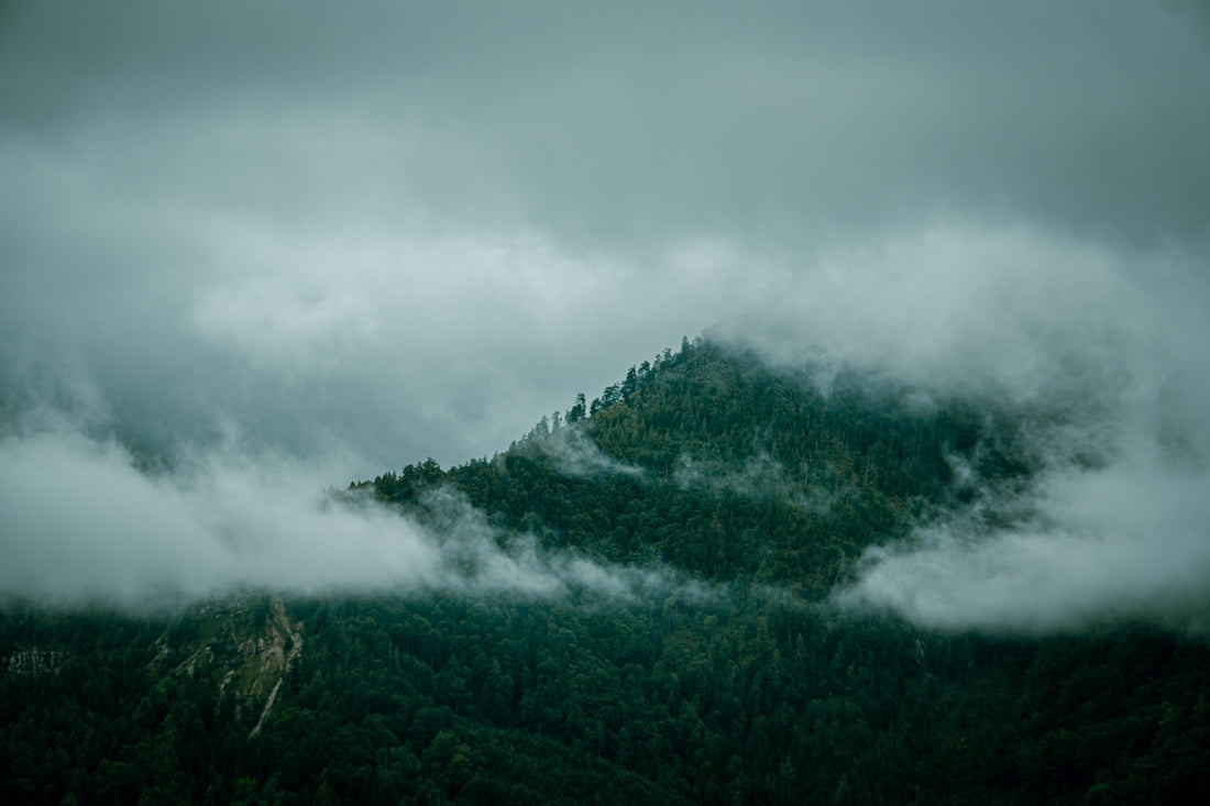 A mountain covered in fog and low lying clouds