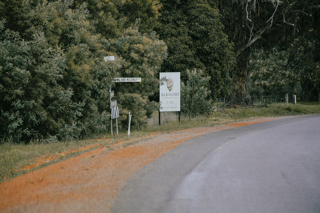 A curved road with a sign on the side of it