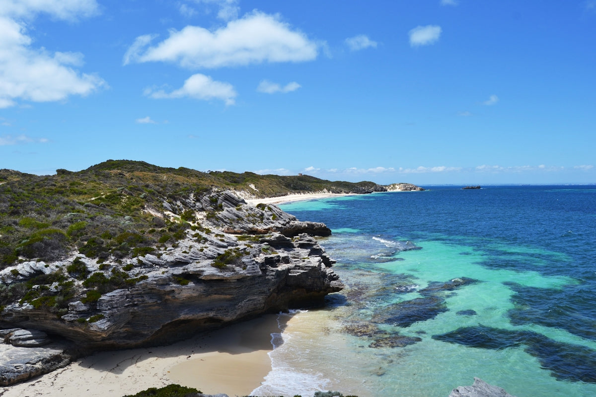 A view of a sandy beach with clear blue water