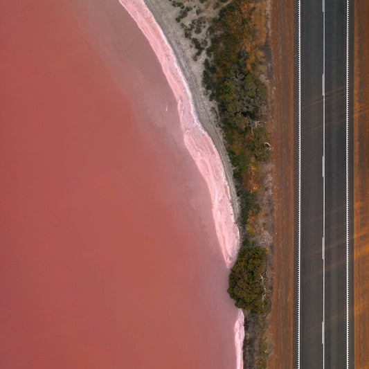 An aerial view of a road near a body of water