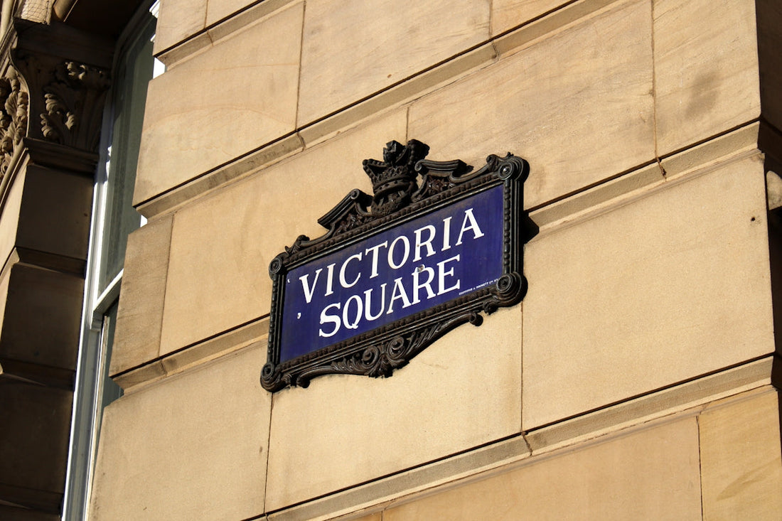 A sign on the side of a building that says victoria square