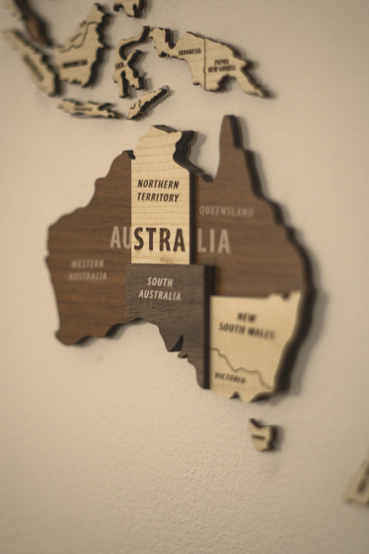 A wooden map of australia on a white wall