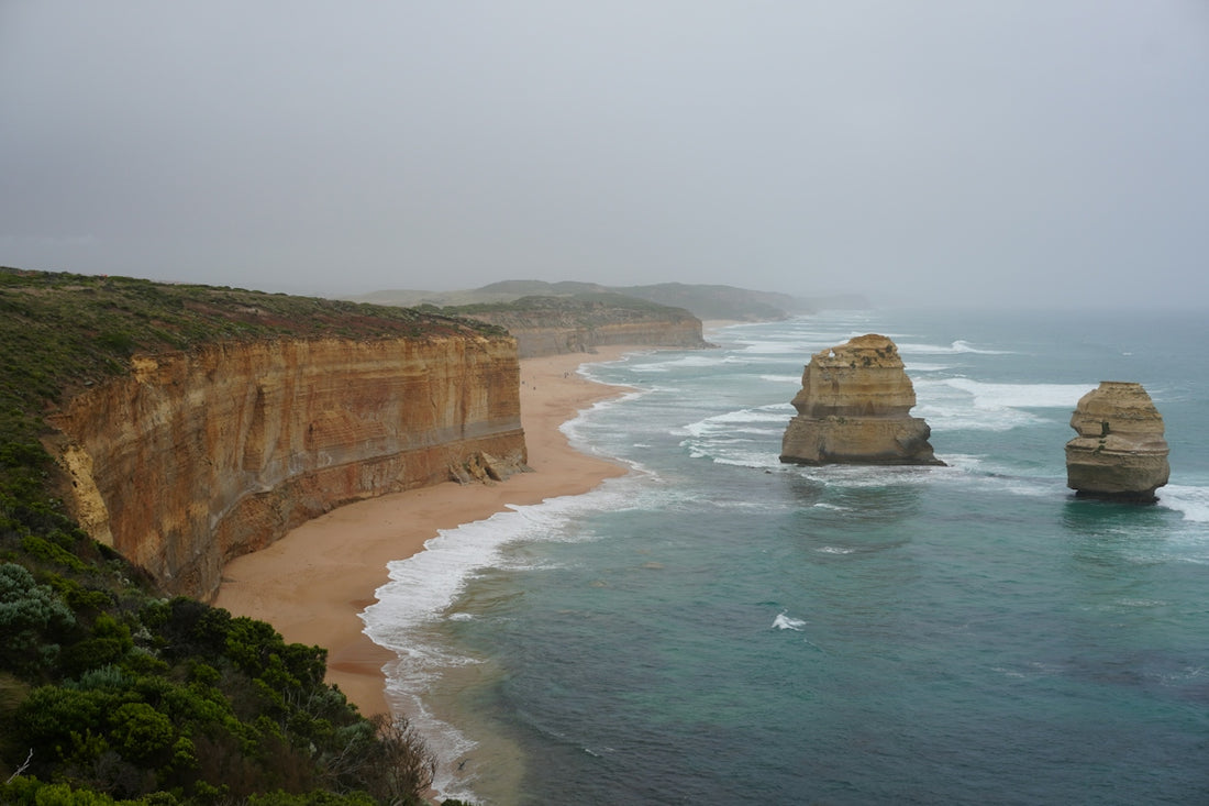 A view of the ocean with two large rocks in the foreground