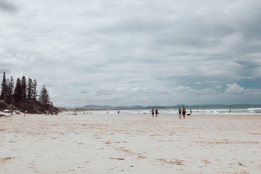 A group of people standing on top of a sandy beach