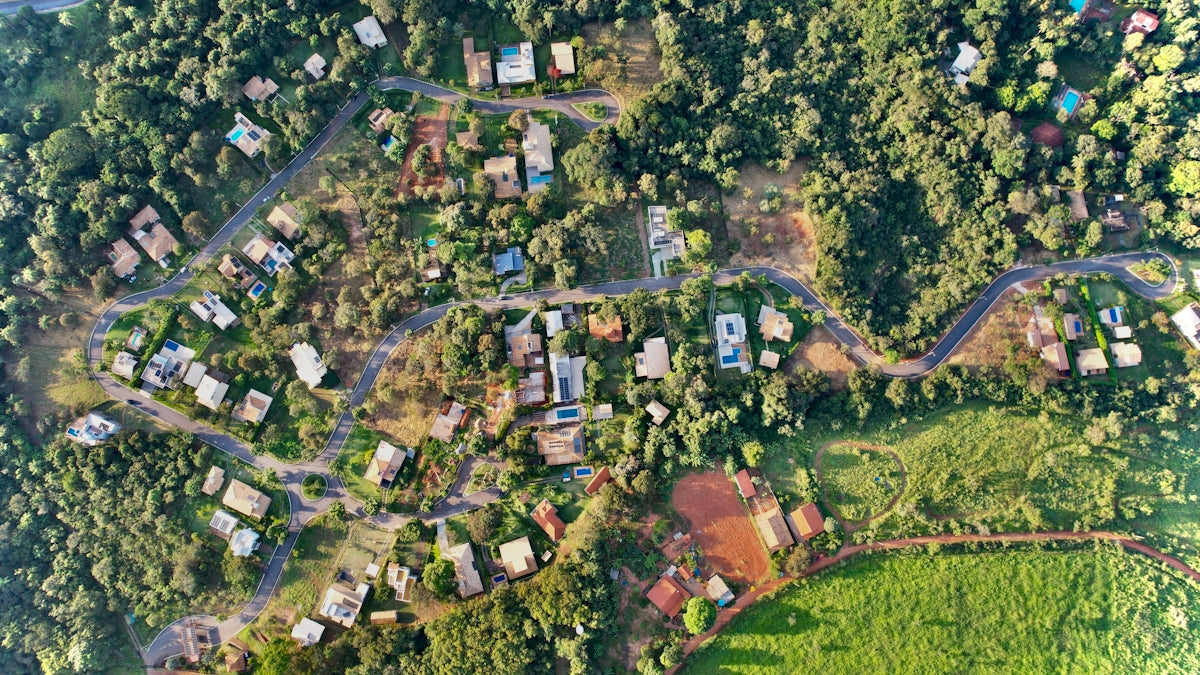 An aerial view of a small village in the middle of a forest