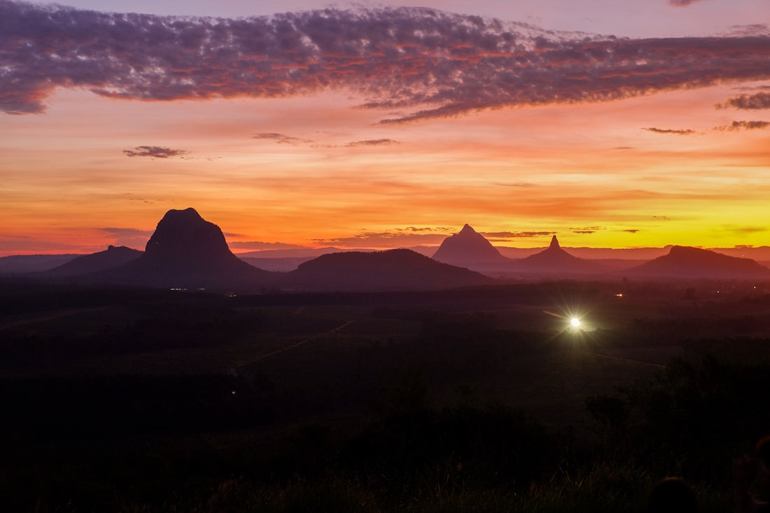 Sunrise paints the sky over mountains.