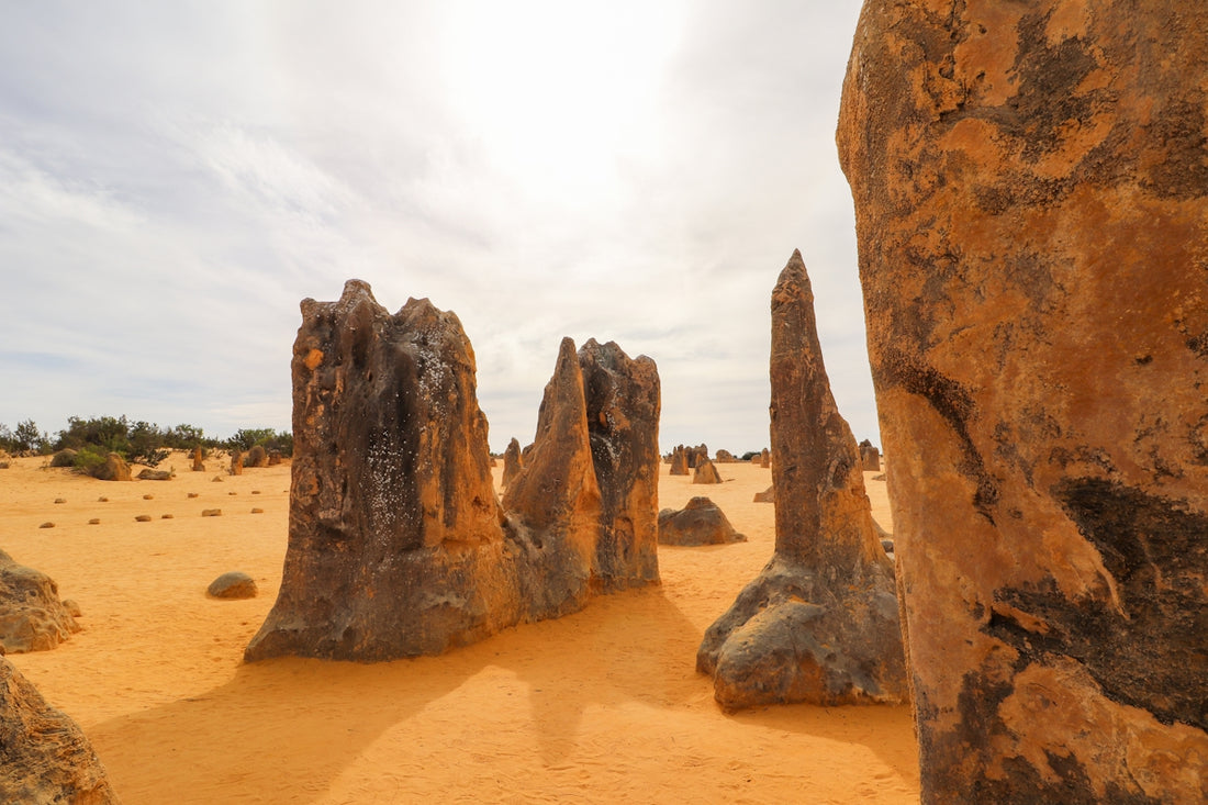 Sand pillars stand tall in a desert landscape.