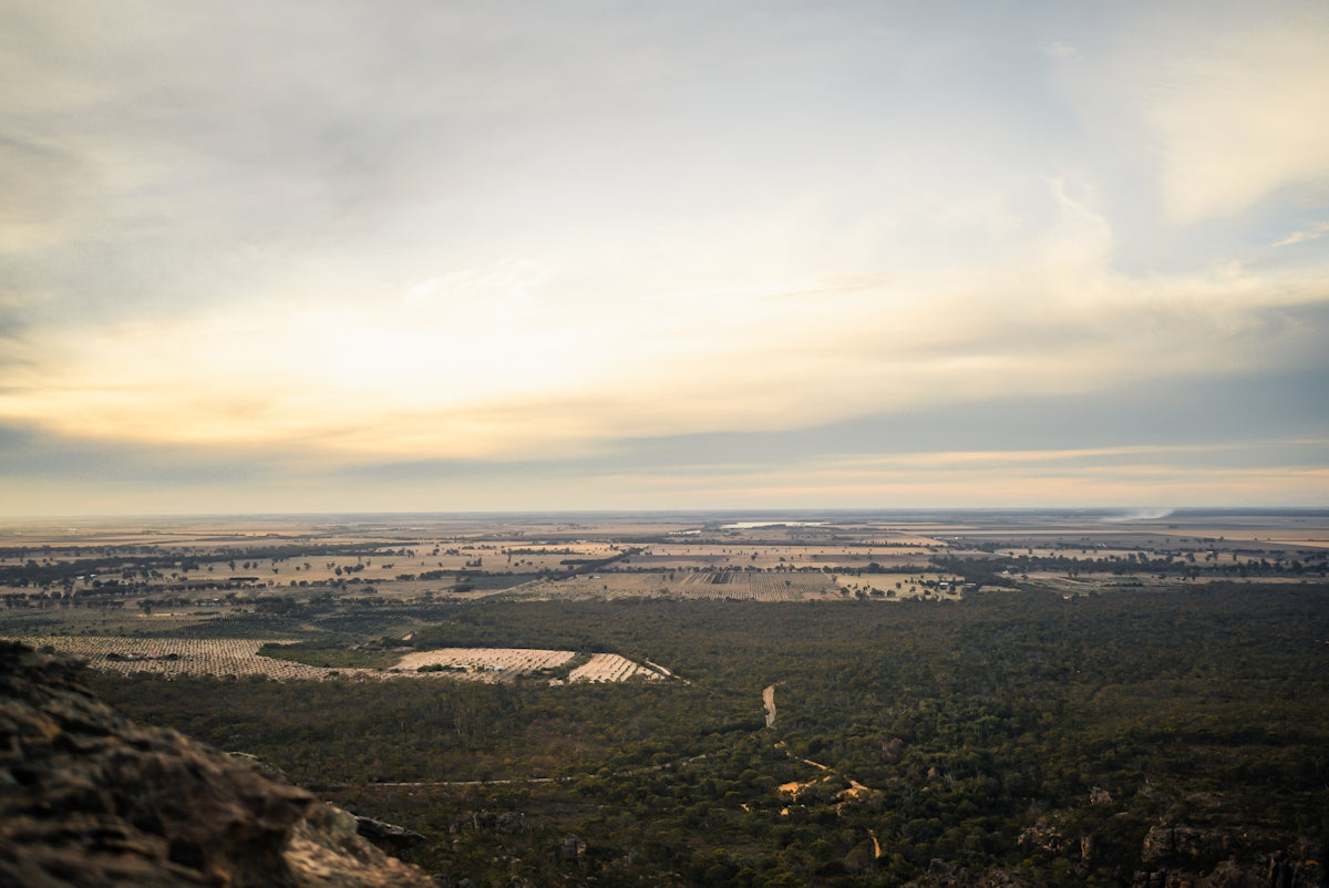 A vast, open landscape stretches under a cloudy sky.