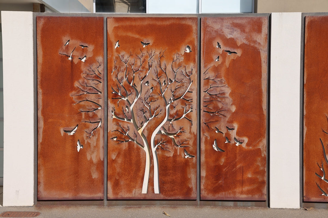 Metal gate with a tree and bird design