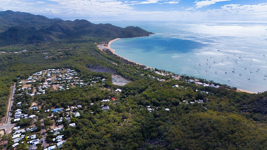 Coastal town nestled among lush green hills by the sea