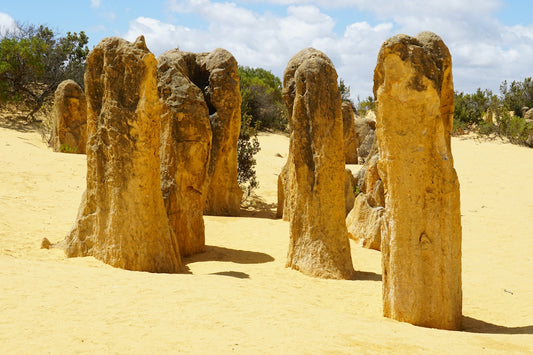 Limestone pinnacles rise from sandy desert landscape.