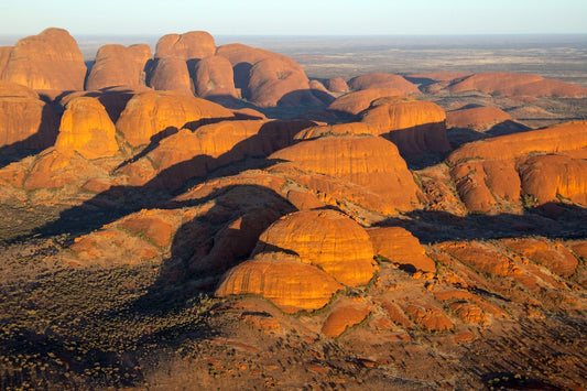 Red rock formations casting long shadows at sunset.