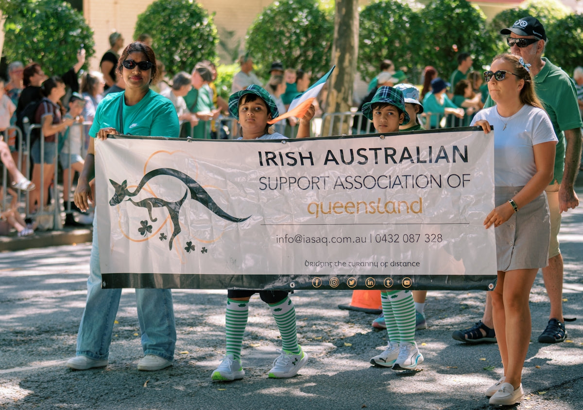 People holding banner for irish australian support association of queensland.